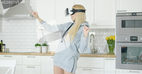 Image of Woman in VR glasses in kitchen