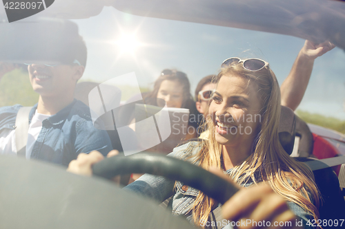 Image of happy friends driving in cabriolet car