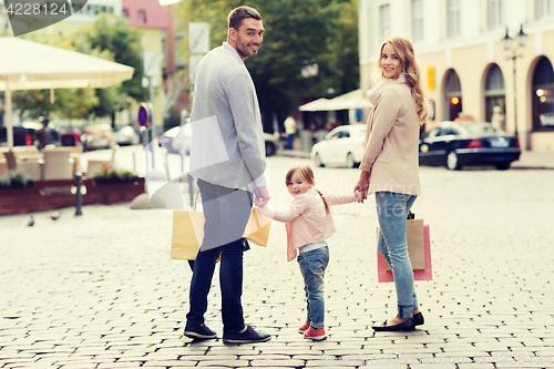 Image of happy family with child and shopping bags in city