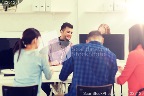 Image of happy creative team or students working at office