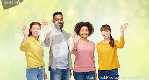 Image of international group of happy people waving hands