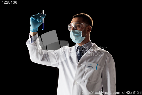 Image of scientist with safety glasses, mask and test tube