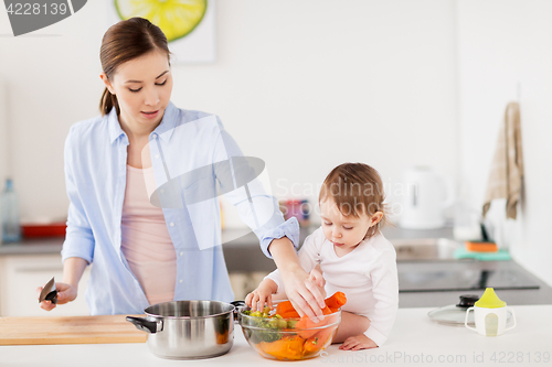 Image of happy mother and baby cooking food at home kitchen