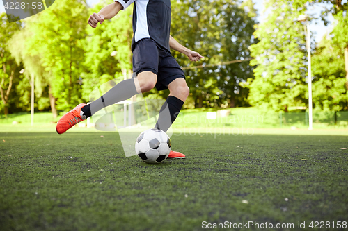 Image of soccer player playing with ball on field