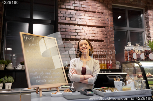 Image of happy woman or barmaid at cafe counter