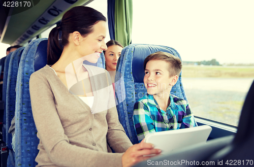 Image of happy family with tablet pc sitting in travel bus