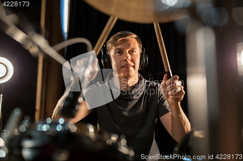 Image of male musician playing drums and cymbals at concert