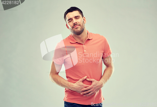 Image of unhappy man suffering from stomach ache