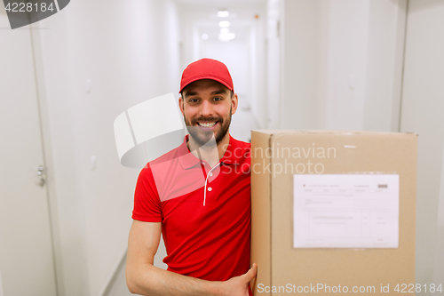Image of delivery man with parcel box in corridor