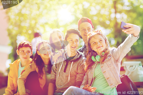 Image of happy teenage students taking selfie by smartphone