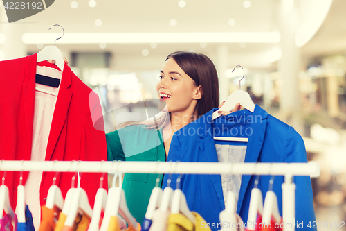 Image of happy woman choosing clothes at home wardrobe