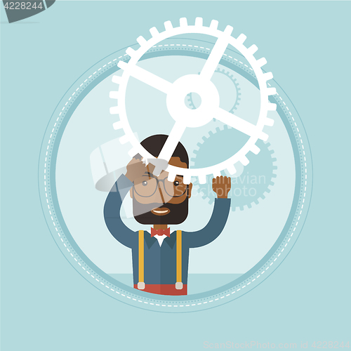 Image of Businessman holding cogwheel above his head.