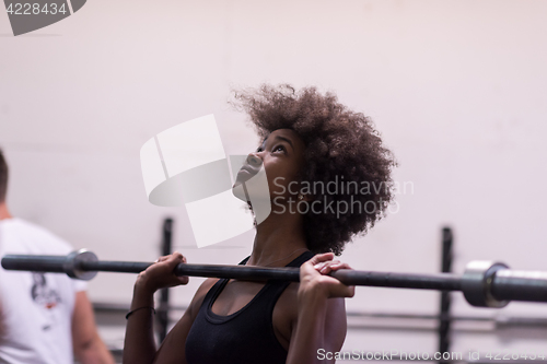 Image of black woman lifting empty bar