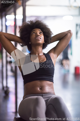 Image of black woman doing sit ups at the gym