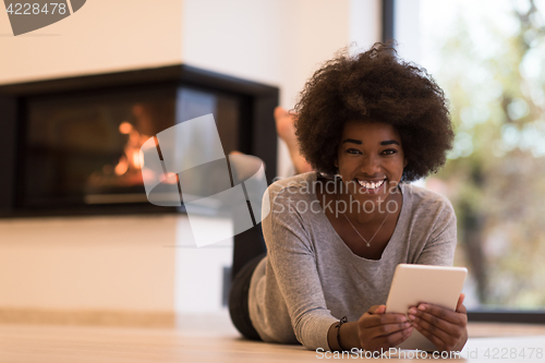 Image of black women using tablet computer on the floor