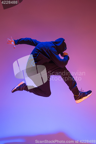 Image of The silhouette of one hip hop male break dancer dancing on colorful background