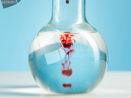 Image of The laboratory glassware and red liquid inside on white