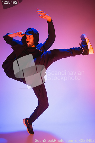 Image of The silhouette of one hip hop male break dancer dancing on colorful background