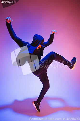 Image of The silhouette of one hip hop male break dancer dancing on colorful background