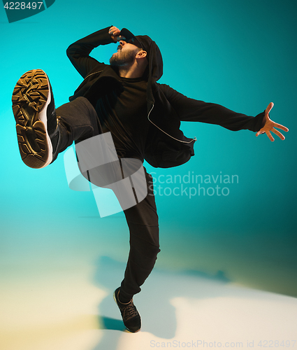 Image of The silhouette of one hip hop male break dancer dancing on colorful background