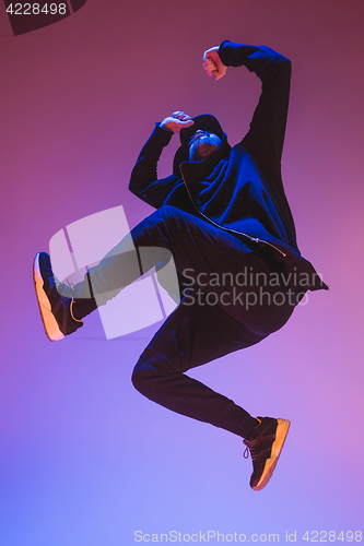 Image of The silhouette of one hip hop male break dancer dancing on colorful background