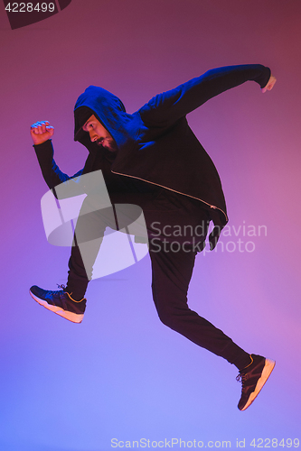 Image of The silhouette of one hip hop male break dancer dancing on colorful background