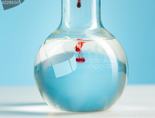 Image of The laboratory glassware and red liquid inside on white