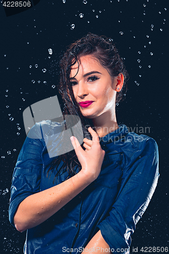 Image of Young beautiful woman under splash of rain