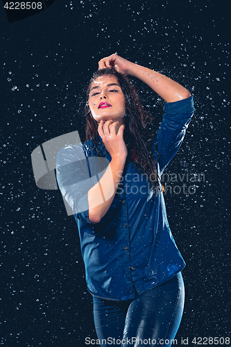 Image of Young beautiful woman under splash of rain