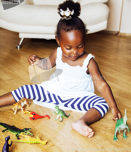 Image of little cute african american girl playing with animal toys at ho