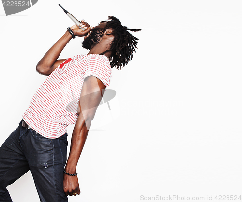 Image of young handsome african american boy singing emotional with microphone isolated on white background, in motion gesturing 