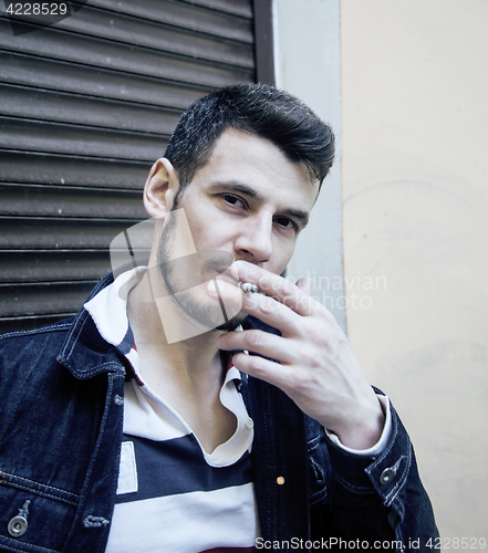 Image of middle age man smoking cigarette on bacyjard, stylish tough guy, lifestyle people concept 