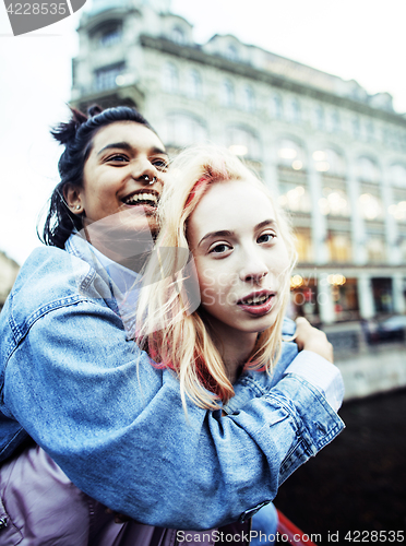 Image of Two teenage girls infront of university building smiling, having