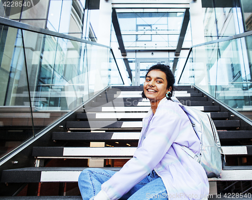 Image of young cute indian girl at university building sitting on stairs 