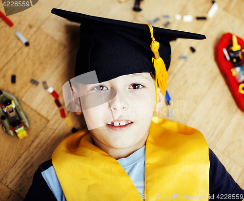 Image of little cute preschooler boy among toys lego at home education in graduate hat smiling posing emotional, lifestyle people concept 