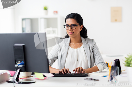 Image of happy businesswoman with computer at office