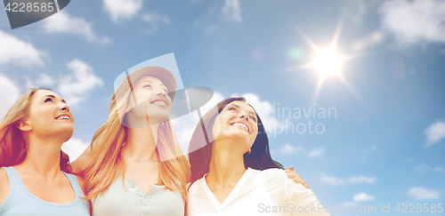 Image of group of happy smiling women or friends over sky