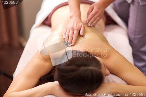 Image of woman having back massage with gel at spa