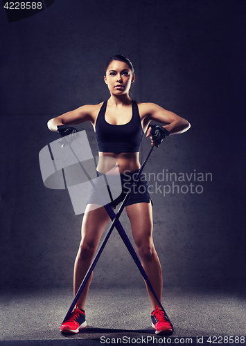 Image of woman with expander exercising in gym