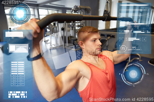 Image of man flexing muscles on cable machine gym