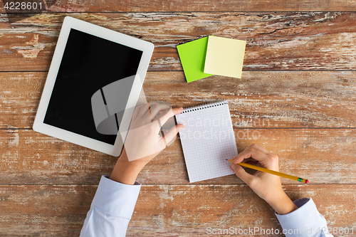 Image of close up of hands with tablet pc and notebook