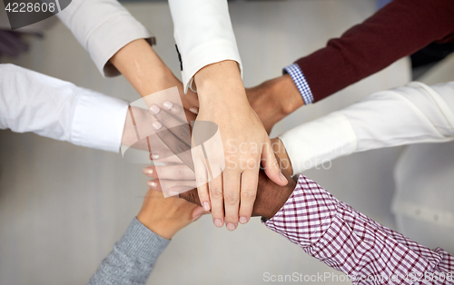 Image of business team with hands on top at office