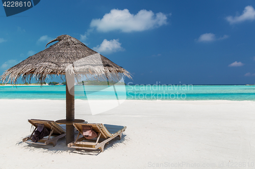 Image of palapa and sunbeds on maldives beach