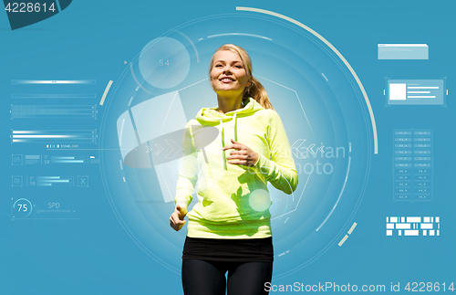 Image of smiling young woman running over blue background