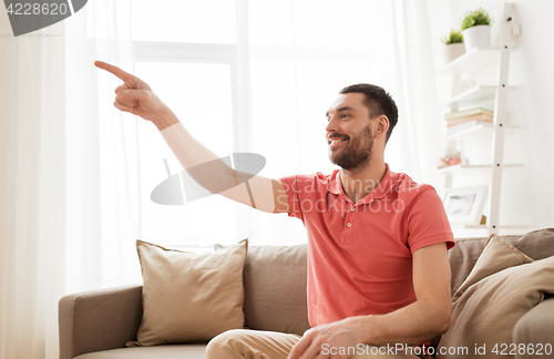 Image of happy man touching something imaginary at home