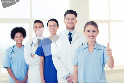 Image of happy doctors showing thumbs up at hospital