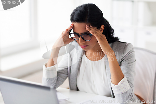 Image of stressed businesswoman with laptop at office