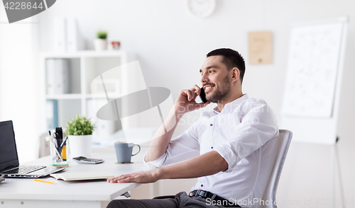 Image of businessman calling on smartphone at office
