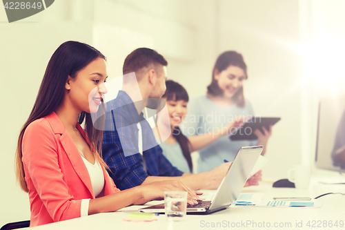 Image of happy african woman over creative team at office