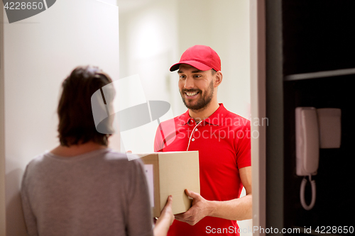 Image of happy delivery man giving parcel box to customer